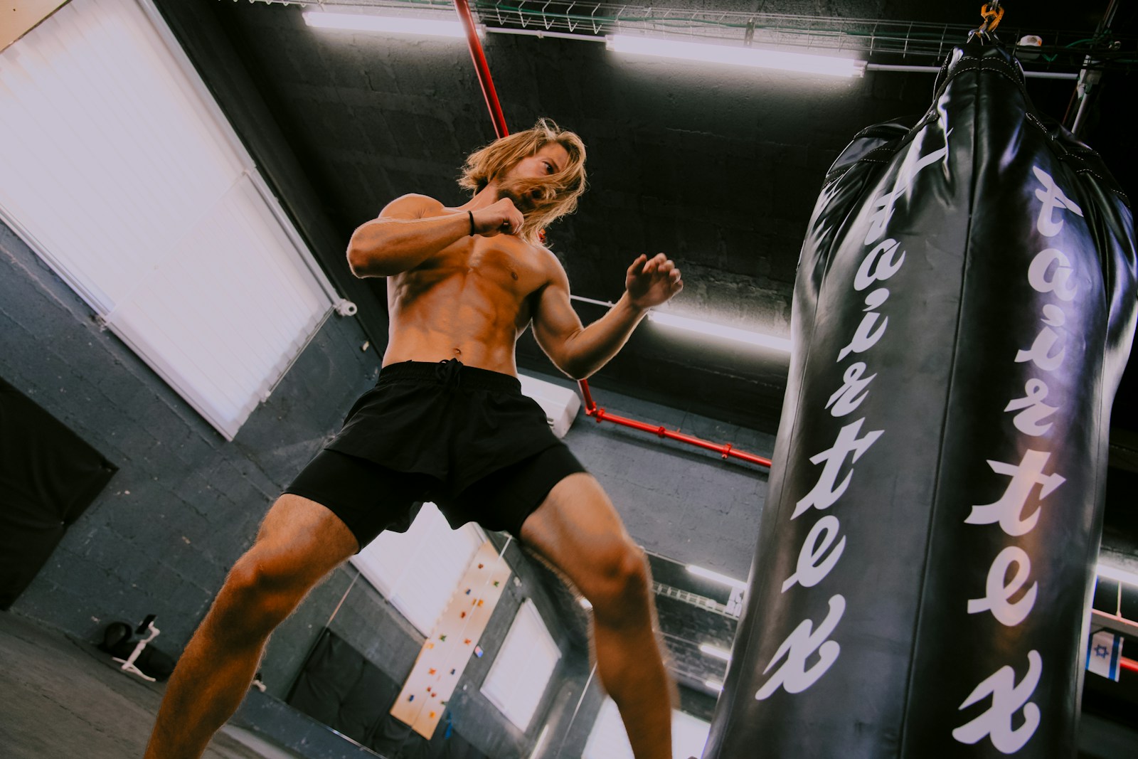 A man standing next to a punching bag